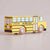 A yellow wooden toy school bus with black and white details, featuring the brand name 'LE TOY VAN' on the side and 'LE TOY VAN' printed on the wheels, set against a plain light beige background.