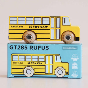 Yellow toy school bus with 'Le Toy Van' branding on a matching box.