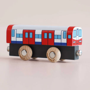Wooden toy train car with red, white, and blue design on a beige background