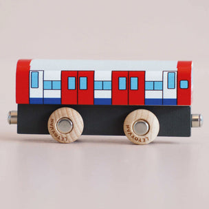 a toy train facing sideways with a plain background 