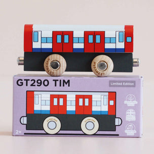 Toy train model with a matching box on a light beige background