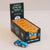 A display box of Le Toy Van limited edition toy cars, with a single blue wooden toy car placed in front on a light beige background.