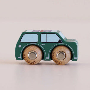 Wooden toy car with green body and brown wheels on a beige background