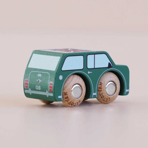 Green wooden toy car with brown wheels on a beige background
