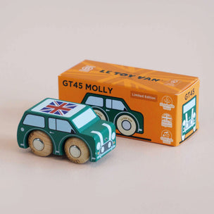 Toy car with Union Jack flag next to its packaging box on a beige background