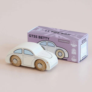 Wooden toy car with 'Le Toy Van' packaging on a beige background