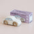 Wooden toy car with 'Le Toy Van' packaging on a beige background