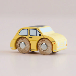 Yellow toy car with wooden wheels on a beige background