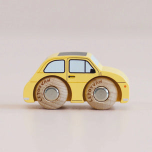 Yellow toy car with wooden wheels on a beige background