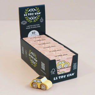 Le Toy Van packaging with a yellow toy car in front on a beige background