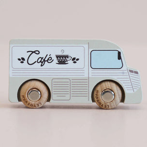 Toy cafe van with wooden wheels on a light background