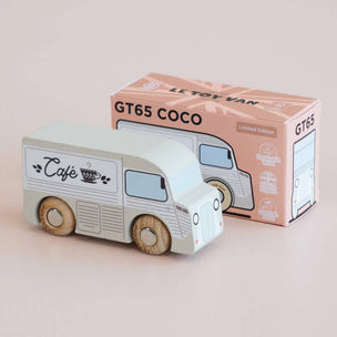 Wooden toy van with 'Cafe' design and packaging on a light pink background