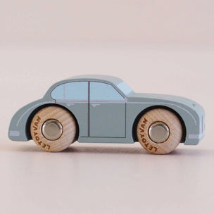 Toy car with wooden wheels on a light beige background