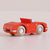 Red toy car with wooden wheels on a beige background