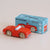 A red wooden toy car with natural wood wheels, shown next to its light blue branded box labeled 'LL TOY VAN GT75 MARC Limited Edition' on a plain light beige background.