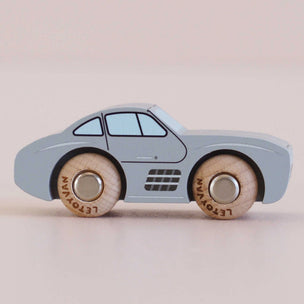 Toy car with wooden wheels on a beige background