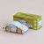 Wooden toy car next to its packaging box on a beige background