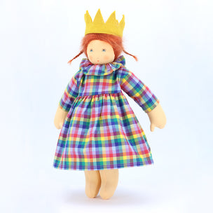 Doll wearing a colorful plaid dress and yellow crown on a white background