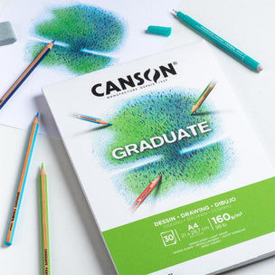 Canson Graduate drawing pad with pencils on a white background