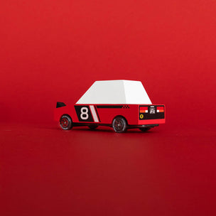 Toy car with a white roof and red body on a red background