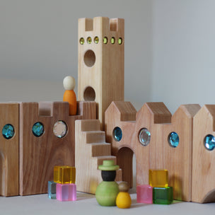 Wooden building blocks with colorful spheres on a gray background