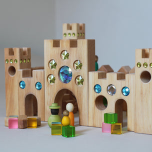 Wooden block castle with colorful gemstones on a gray background