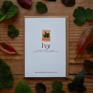 Card with 'Ivy' design on a wooden surface with leaves