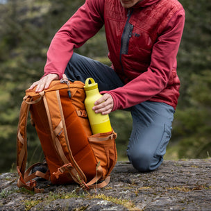 Person in outdoor setting with backpack and yellow water bottle