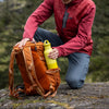 Person in outdoor setting with backpack and yellow water bottle