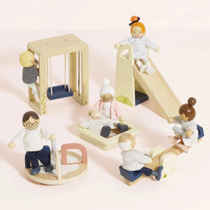 Wooden toy figures of children playing on a playground set with a slide, swing, and climbing structure.