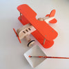 Red toy airplane with wooden propeller on a white background