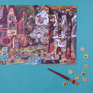 A colorful illustrated puzzle featuring a whimsical forest scene with characters, placed on a bright turquoise background with a wooden stick and several small round pieces nearby.
