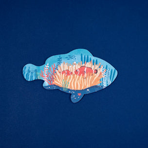 Decorative fish-shaped cutout with coral and fish on a blue background