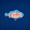 Decorative fish-shaped cutout with coral and fish on a blue background