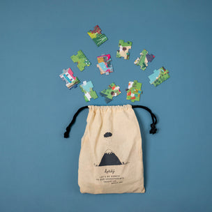 Puzzle pieces scattered around a beige drawstring bag on a blue background