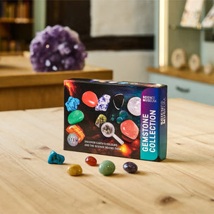 Box of gemstone collection on a wooden table with gemstones around