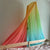 Gradient fabric canopy over a bed with a plain wall background