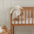 Wooden crib with baby blanket and toy in a nursery setting
