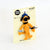 A Shaun the Sheep keychain charm on its original cream-colored backing card, featuring the character in orange with a blue cap and black nose.