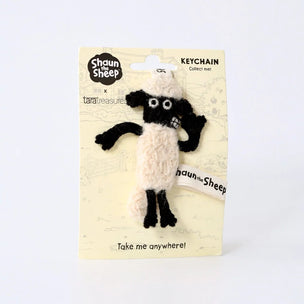 Shaun the Sheep collect cap keychain by tarageneut on its original backing card, featuring a plush sheep design with a cream-colored body and black head, horns, and legs.