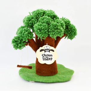 A handmade felt sheep tree toy with green yarn-style leaves, a brown felt trunk, a green felt base, and a hanging swing. A cream-colored tag on the trunk reads 'Shaun the Sheep' with a cartoon sheep logo.