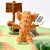 A small plush sheep character stands on a green felt surface, holding a white sign that reads 'Shaun the Sheep.' Behind it is a wooden sign reading 'Welcome to Mossy Bottom Farm.