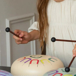 Young girl playing a musical instrument with colorful lettering