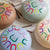 Three colorful drums with abstract patterns on a light fabric background