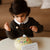 Child playing with a musical instrument on a table
