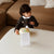 Child playing with a toy on a coffee table in a living room.