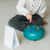 Child playing with a drum on a light-colored floor.