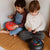 Two children sitting on the floor playing with colorful toys.