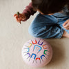 Child playing with a colorful toy on a beige carpet