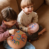 Two children playing with colorful instruments on a couch